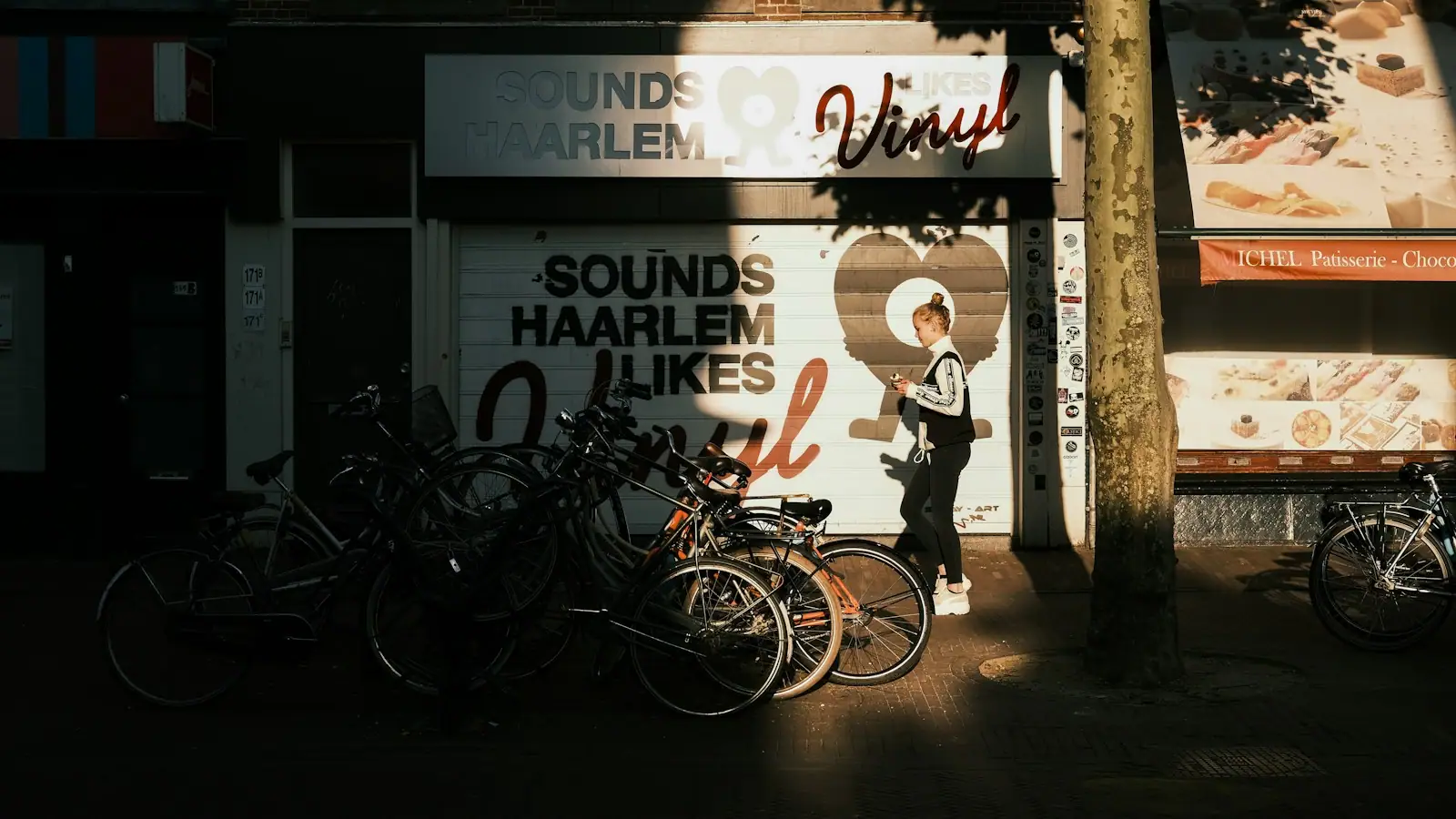 Man in black jacket and pants standing beside bicycle