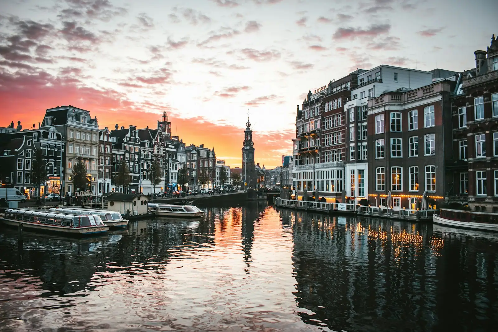 White boat on river between buildings during daytime