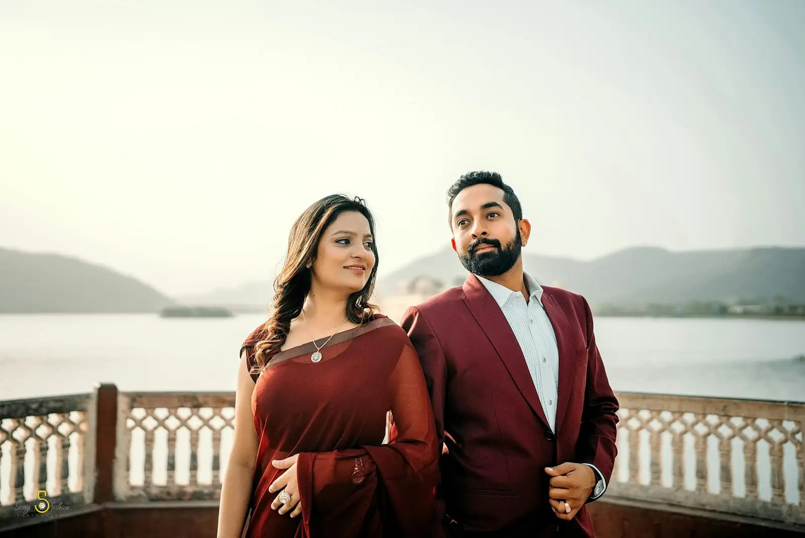 A couple poses by the water for a photo
