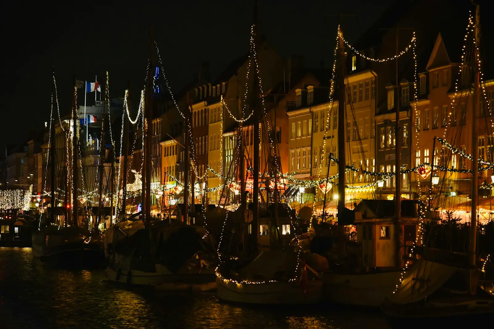 Sailboats decorated with christmas lights at night