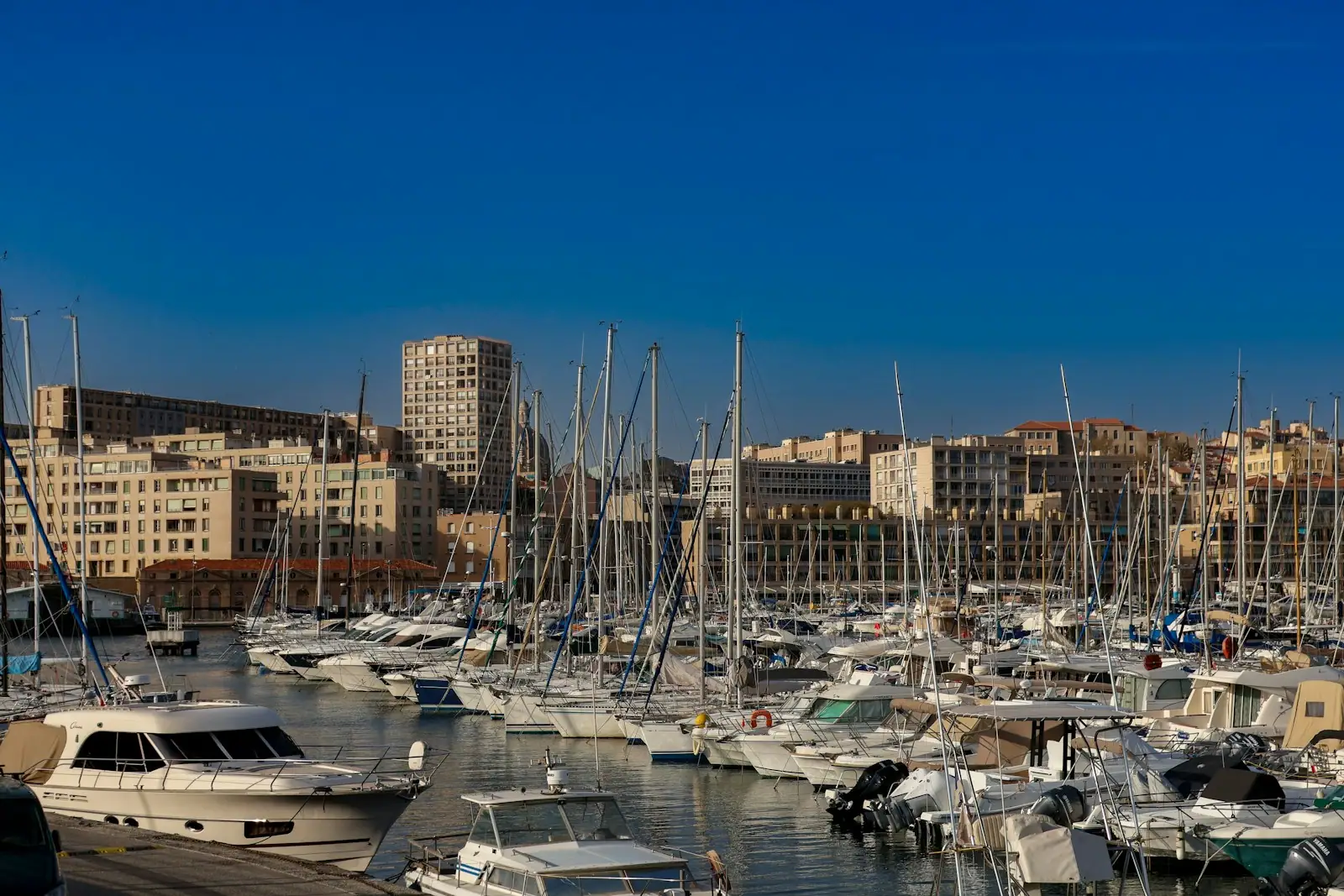 A harbor filled with lots of boats next to tall buildings