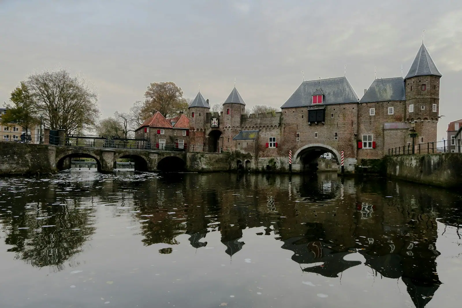 Gray concrete bridge to castle under cloudy sky during daytime