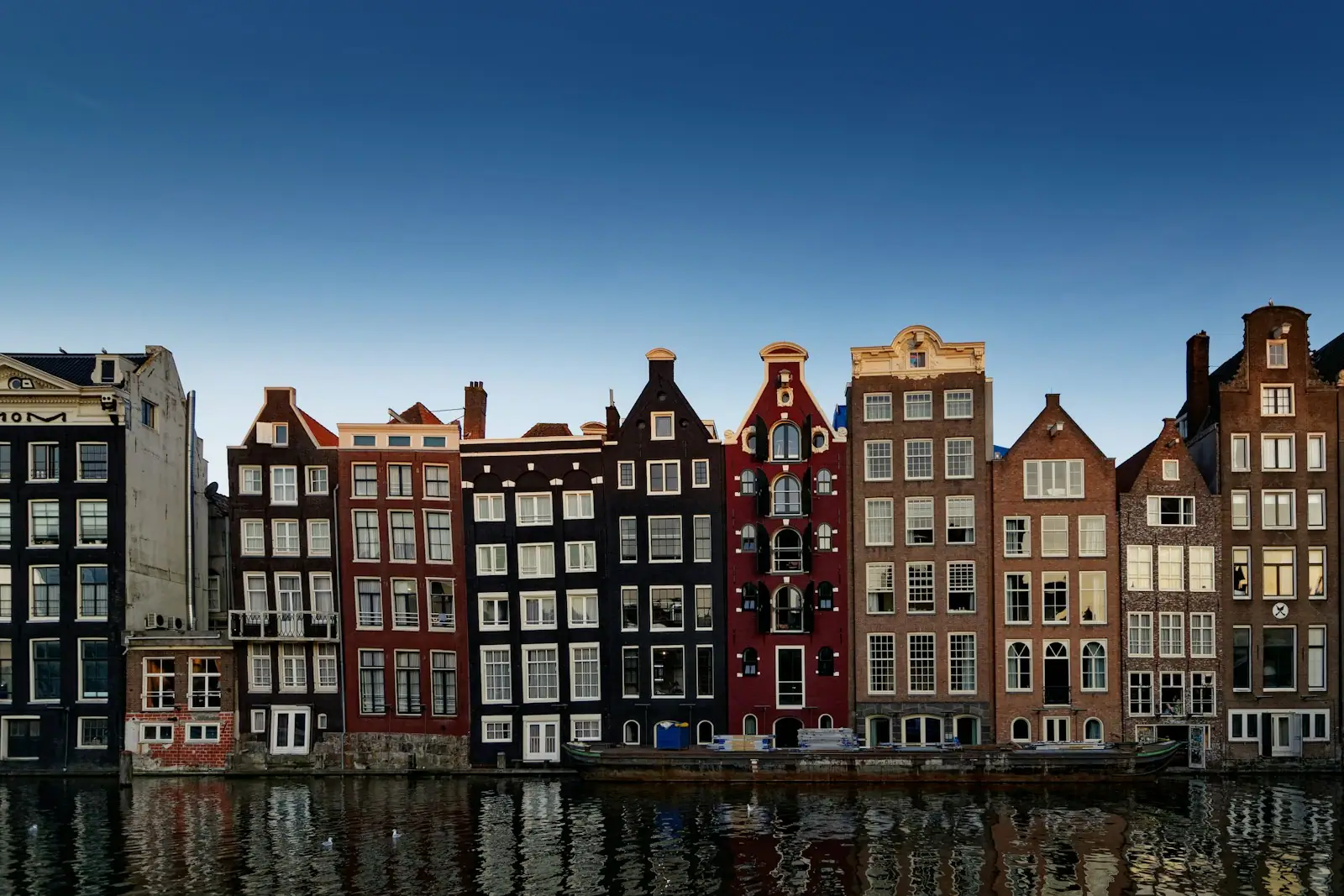 Red and white concrete building beside body of water during daytime