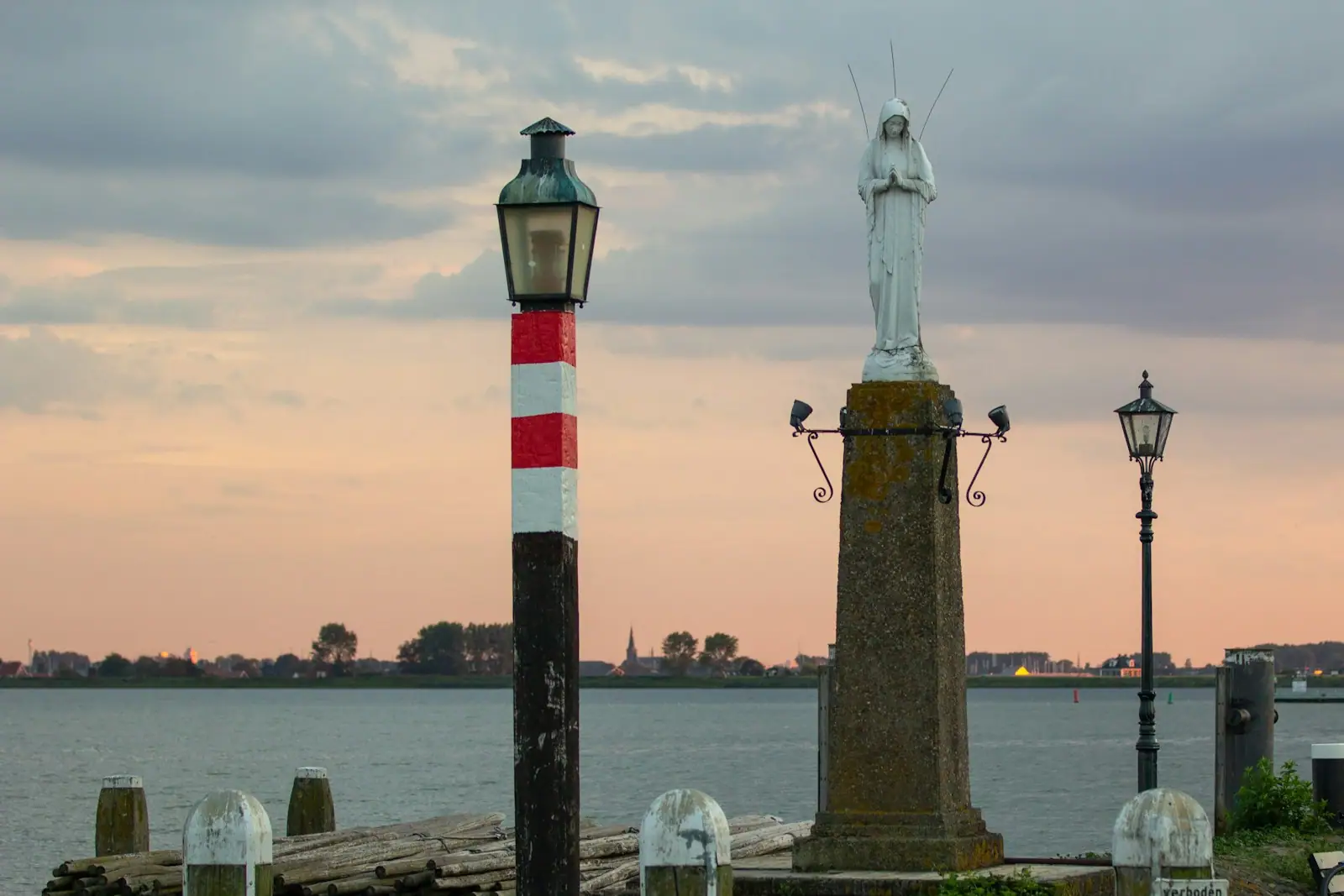 Black and red lighthouse near body of water during daytime