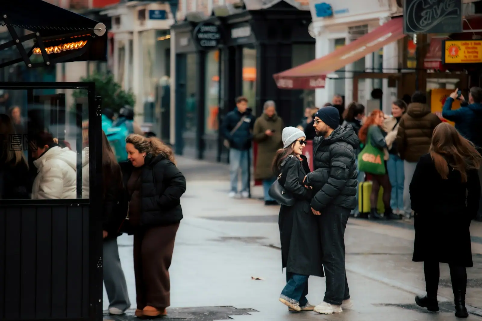 Couple embracing on a busy street with blurred background