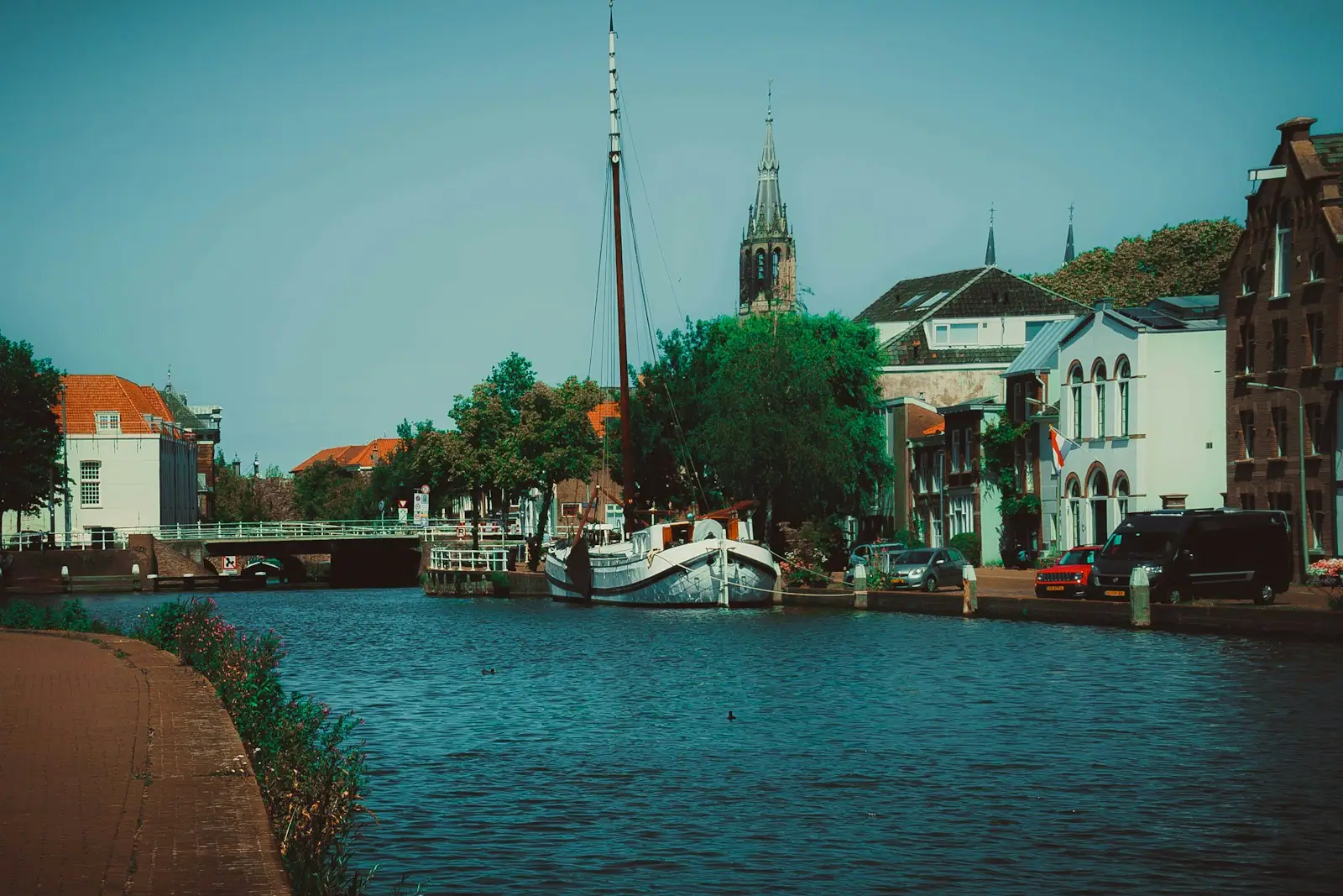 A boat floating on top of a river next to tall buildings