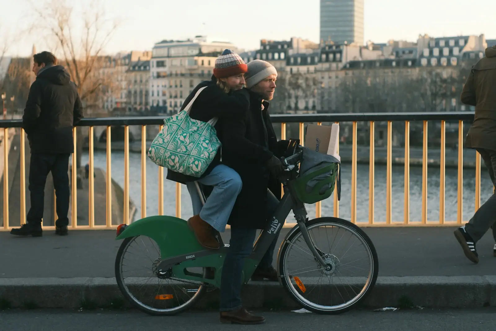Couple riding a bicycle across a bridge
