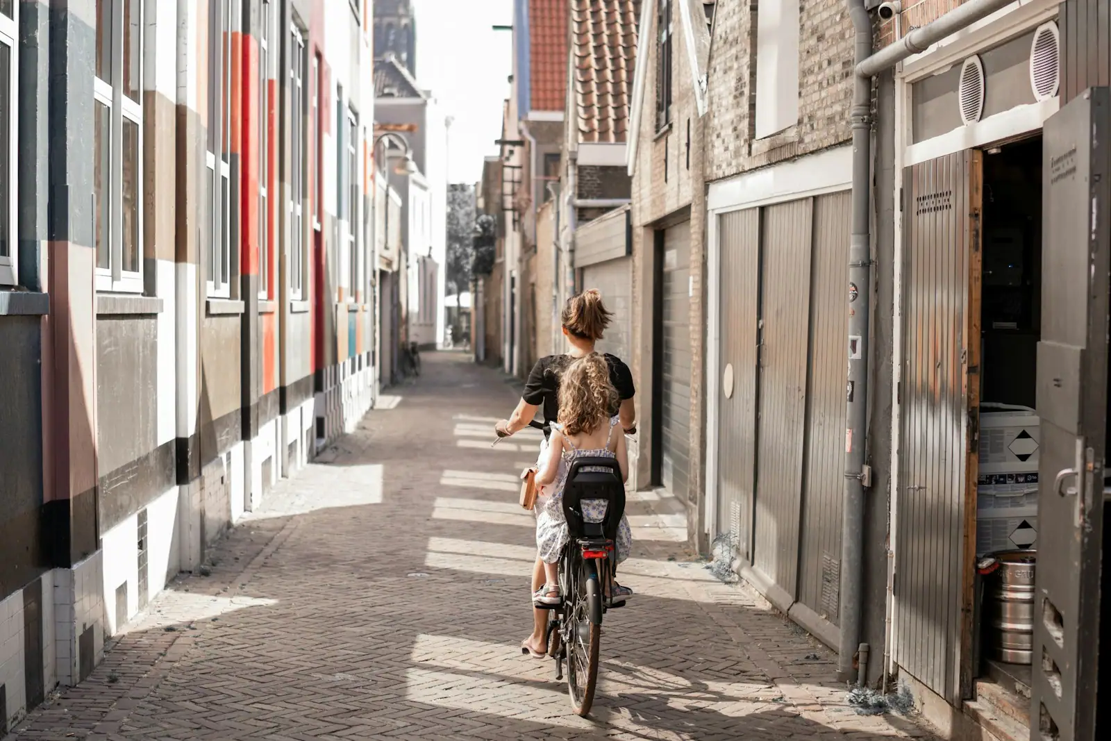 A couple of people riding bikes down a street
