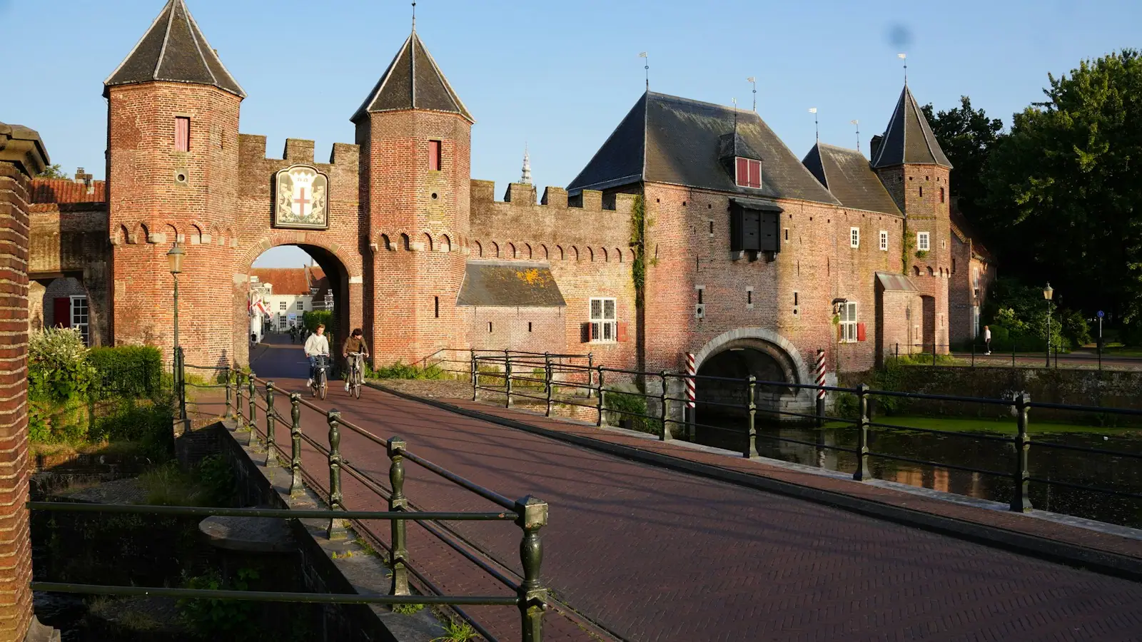 A large brick castle with a bridge leading to it