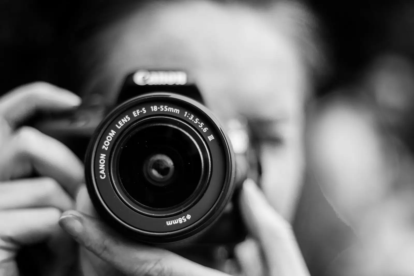Person taking photo using Canon camera in shallow focus lens