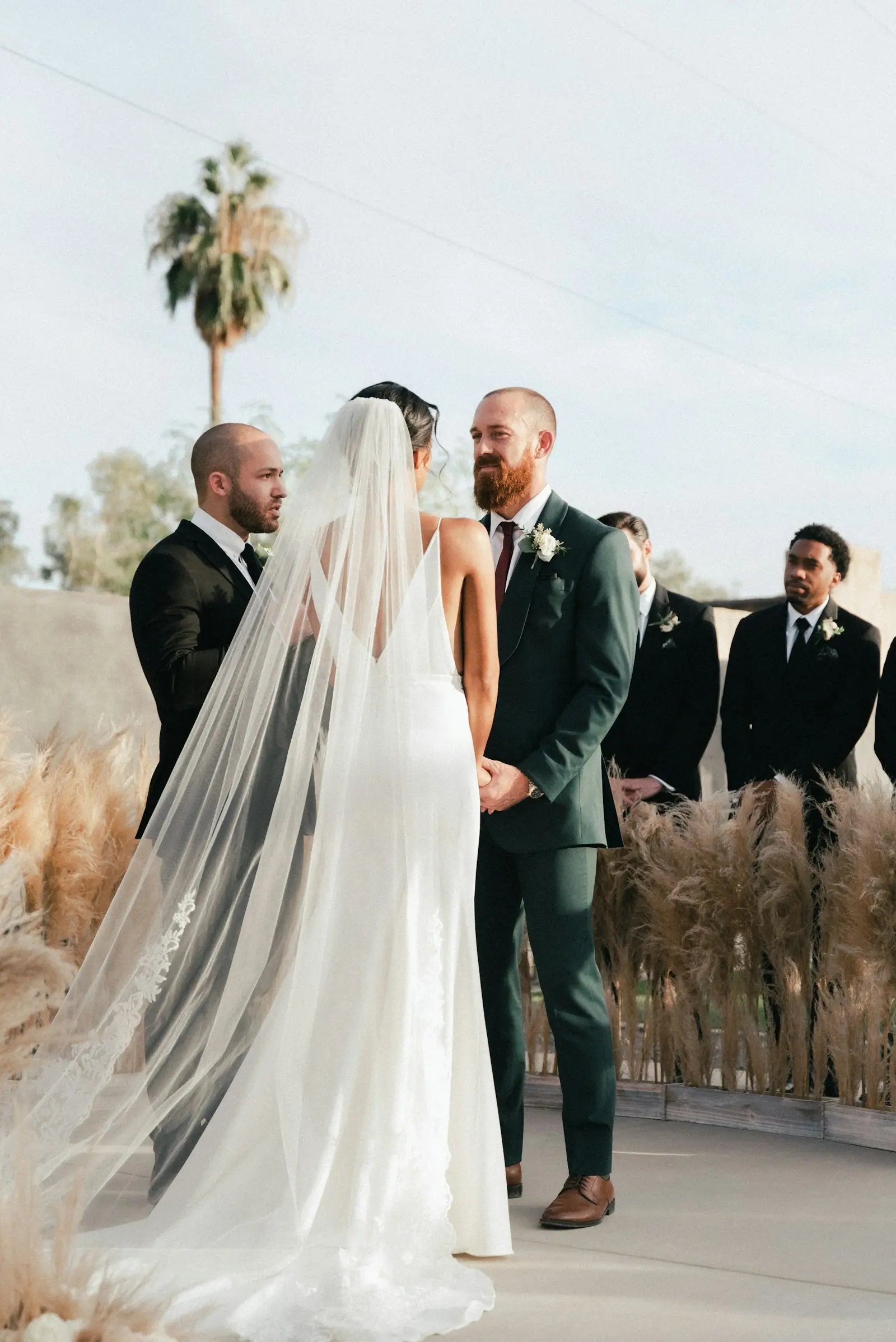 Bride and groom standing on grass field during daytime