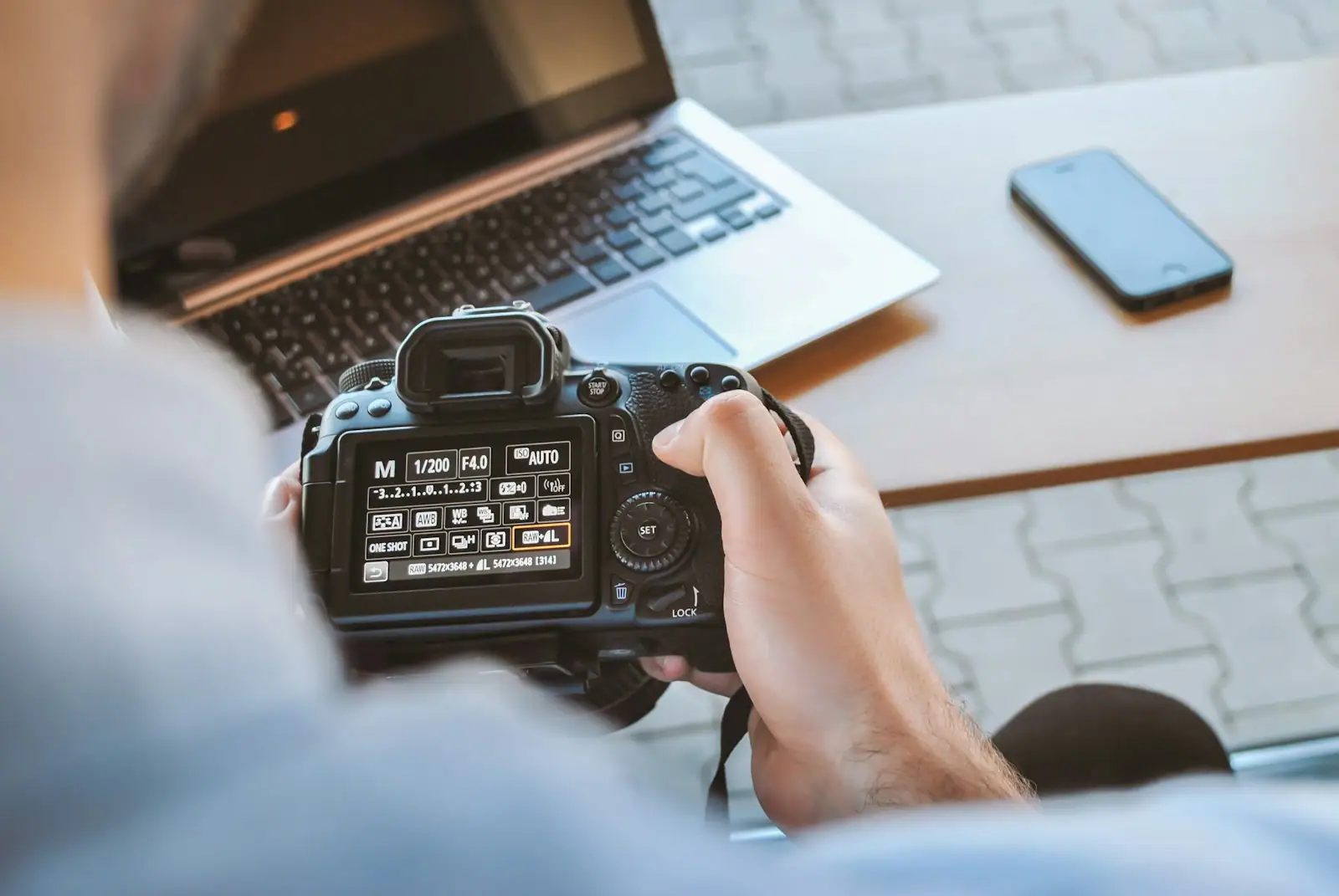 Person holding black DSLR camera