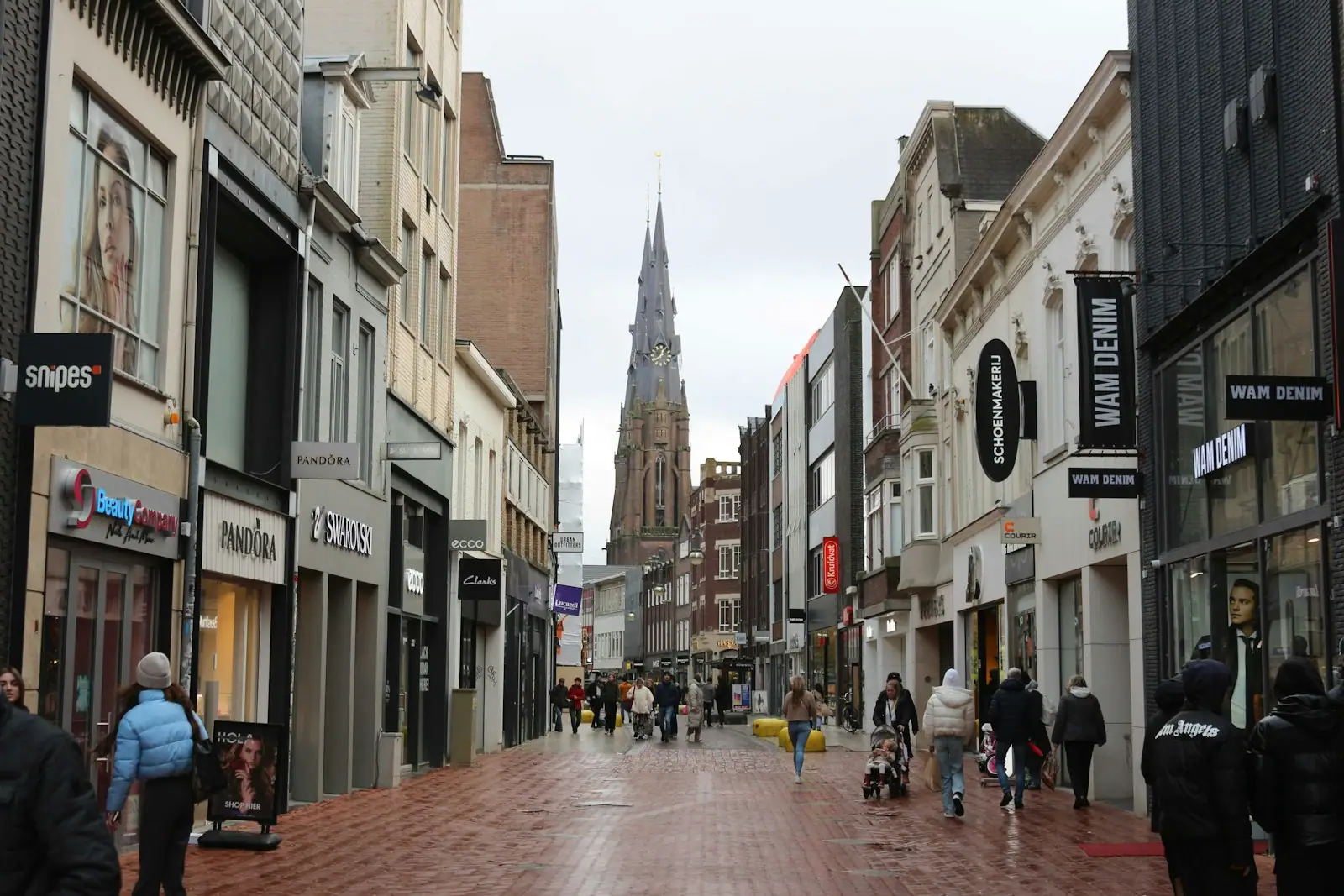A busy street leads to a spired church