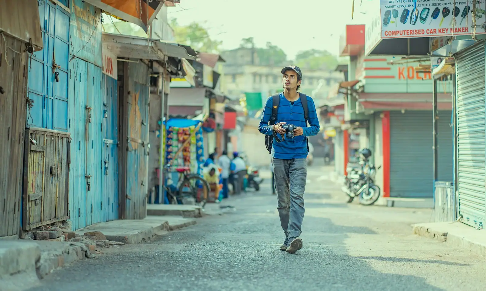 A woman walking down a street with a camera