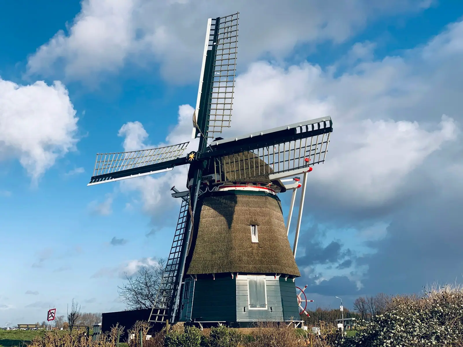 Brown and white windmill under blue sky during daytime