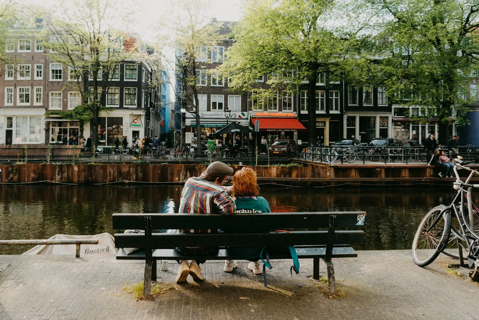 Two people sitting on a bench near a body of water