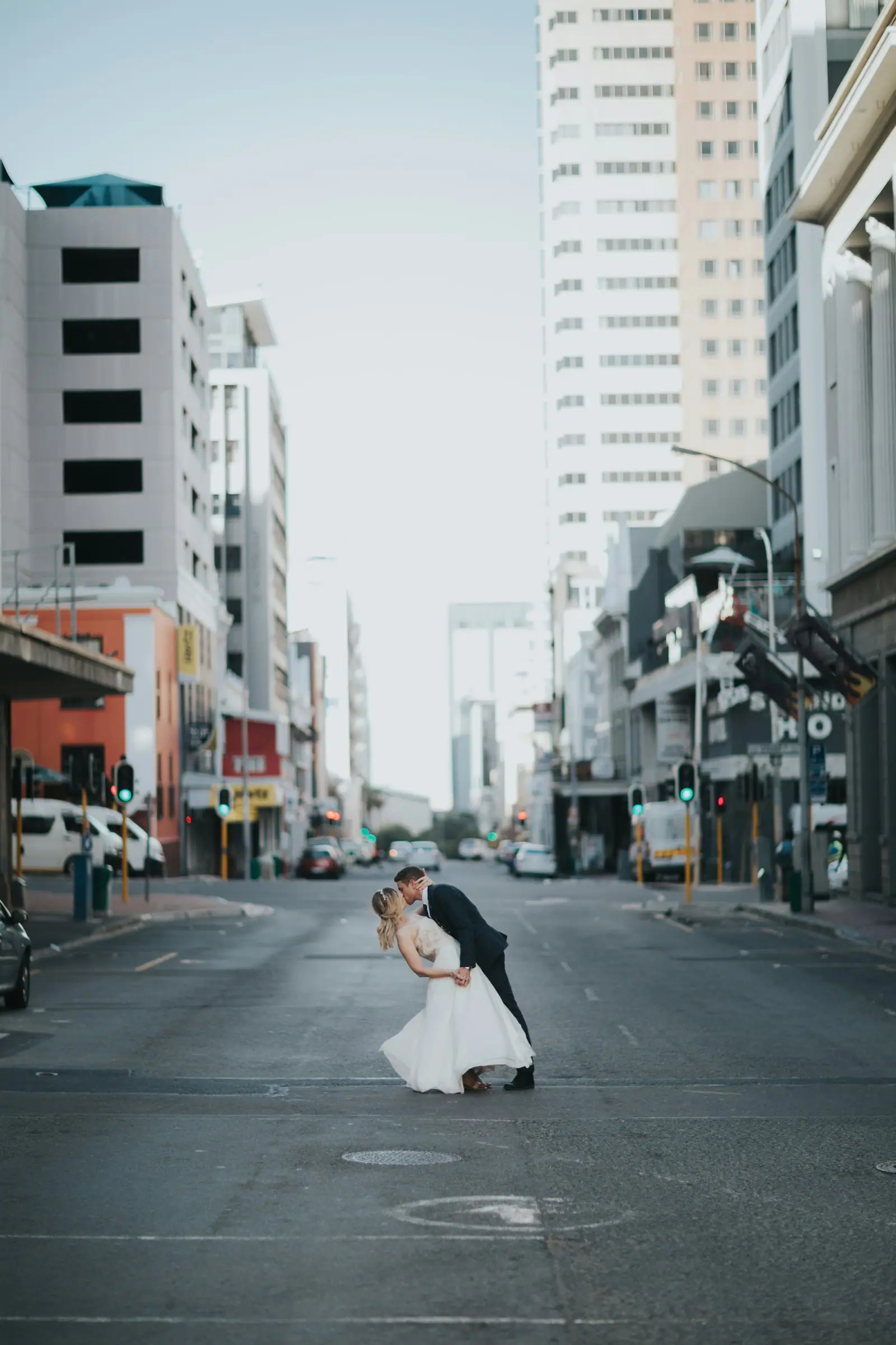 Bride and groom kissing in the middle of roas